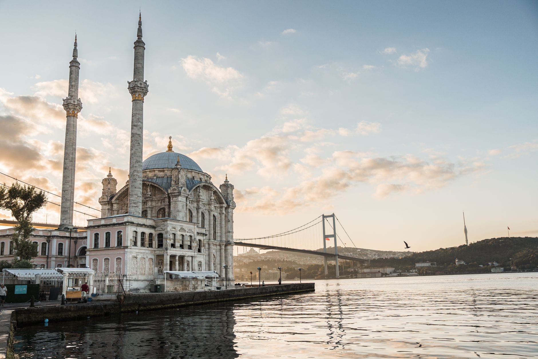 La Moschea di Ortaköy all'alba sul lungofiume del Bosforo, con il Ponte sul Bosforo sullo sfondo e la luce dorata che si riflette sull'acqua.
