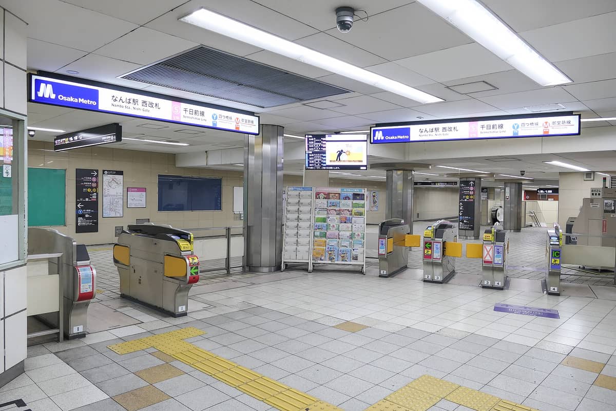Wide view of Osaka Metro ticket gates at Namba Station, showing clear Osaka Metro signage and station information in a clean, modern transit environment.
