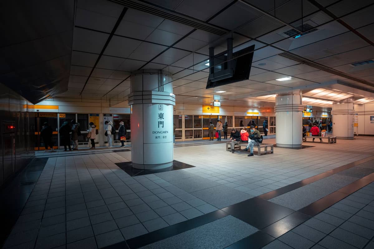 Osaka metro station interior at night with passengers waiting on benches and platform