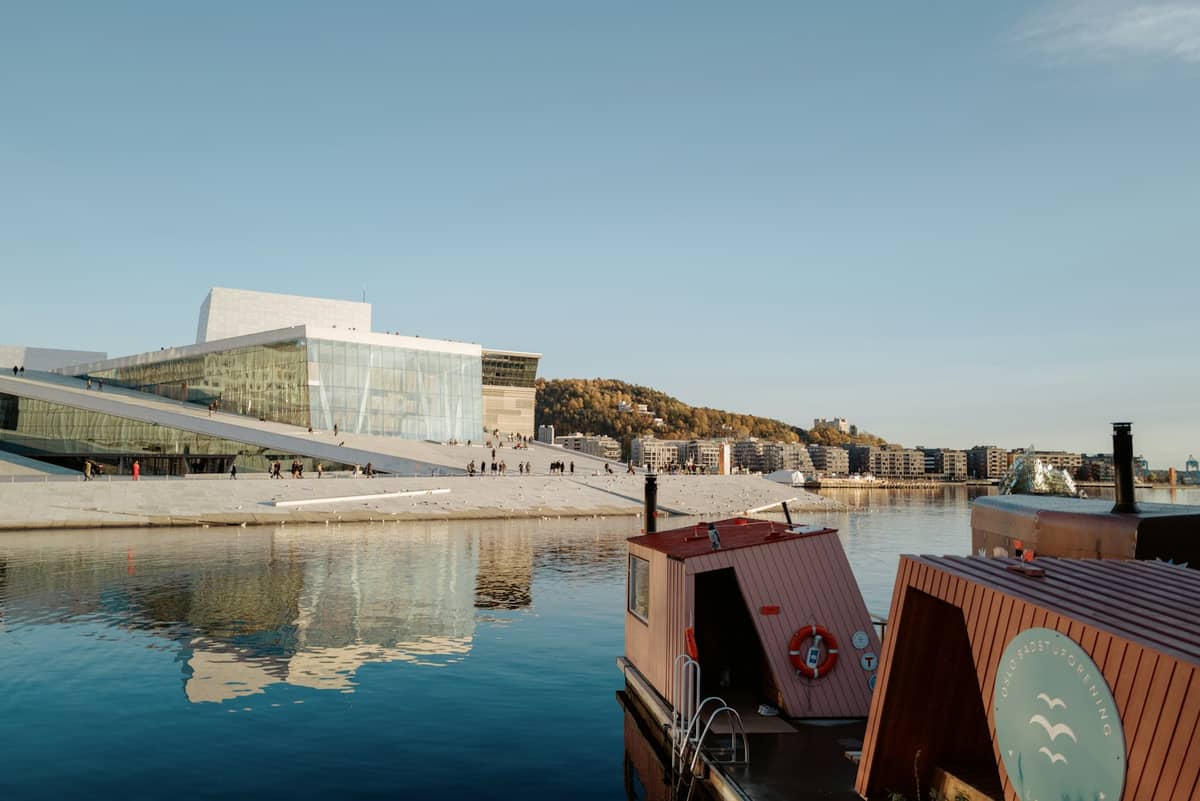 เซาน่าลอยน้ำที่จอดเทียบท่าในท่าเรือออสโลโดยมี Oslo Opera House เป็นฉากหลังในวันที่ท้องฟ้าแจ่มใส