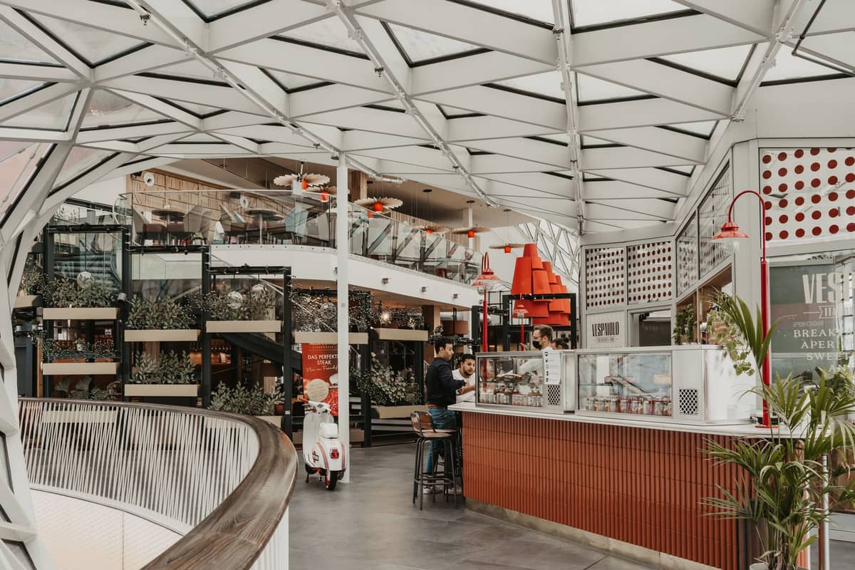 ฟู้ดคอร์ตหรือตลาดในร่มสมัยใหม่ในเมือง Oslo พร้อมร้านอาหารหลากหลาย พื้นที่นั่งรับประทาน และผู้คนที่กำลังสั่งอาหารหรือรับประทานอาหาร