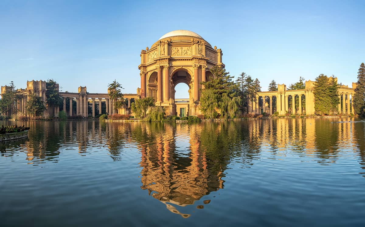 Vista panorámica amplia del Palacio de Bellas Artes en San Francisco con su gran rotonda y la laguna reflejando la estructura en un día despejado.