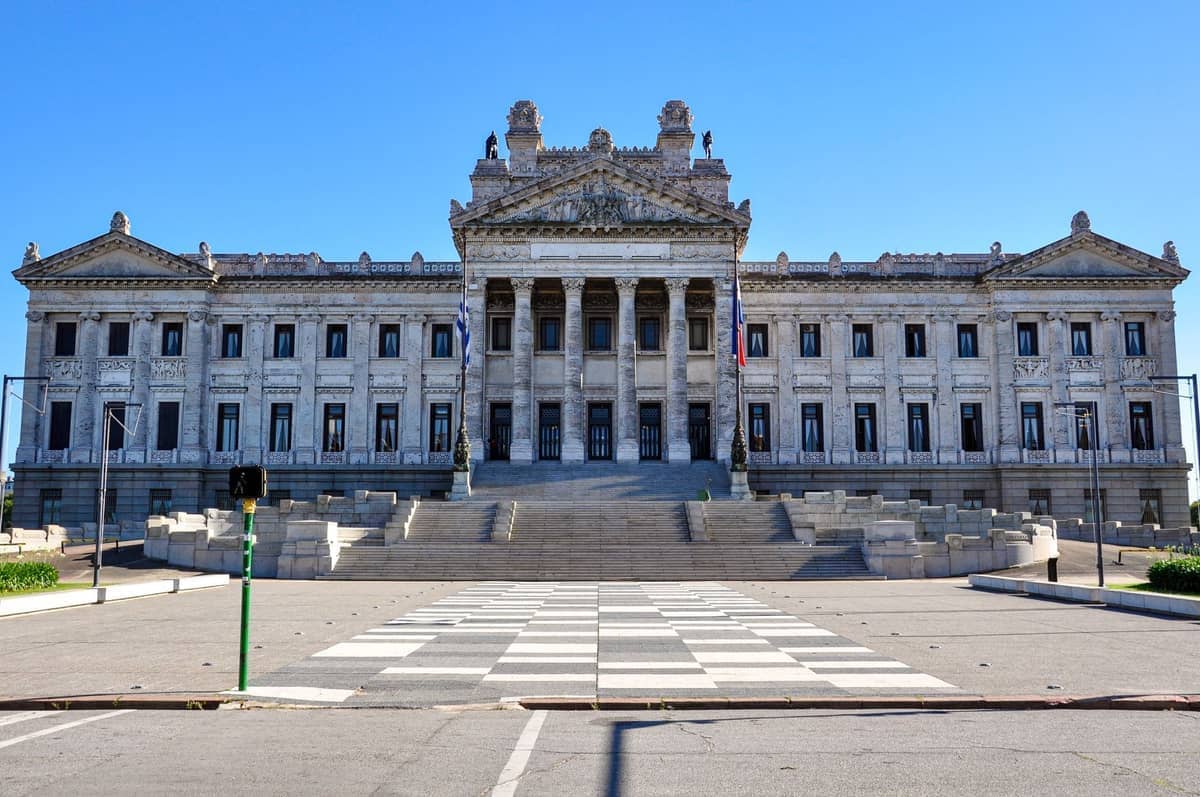 ภาพด้านหน้าของ Palacio Legislativo ในมอนเตวิเดโอ แสดงให้เห็นส่วนหน้าแบบนีโอคลาสสิกอันยิ่งใหญ่ เสาหินอ่อน และขั้นบันไดหินกว้างในวันที่อากาศแจ่มใส