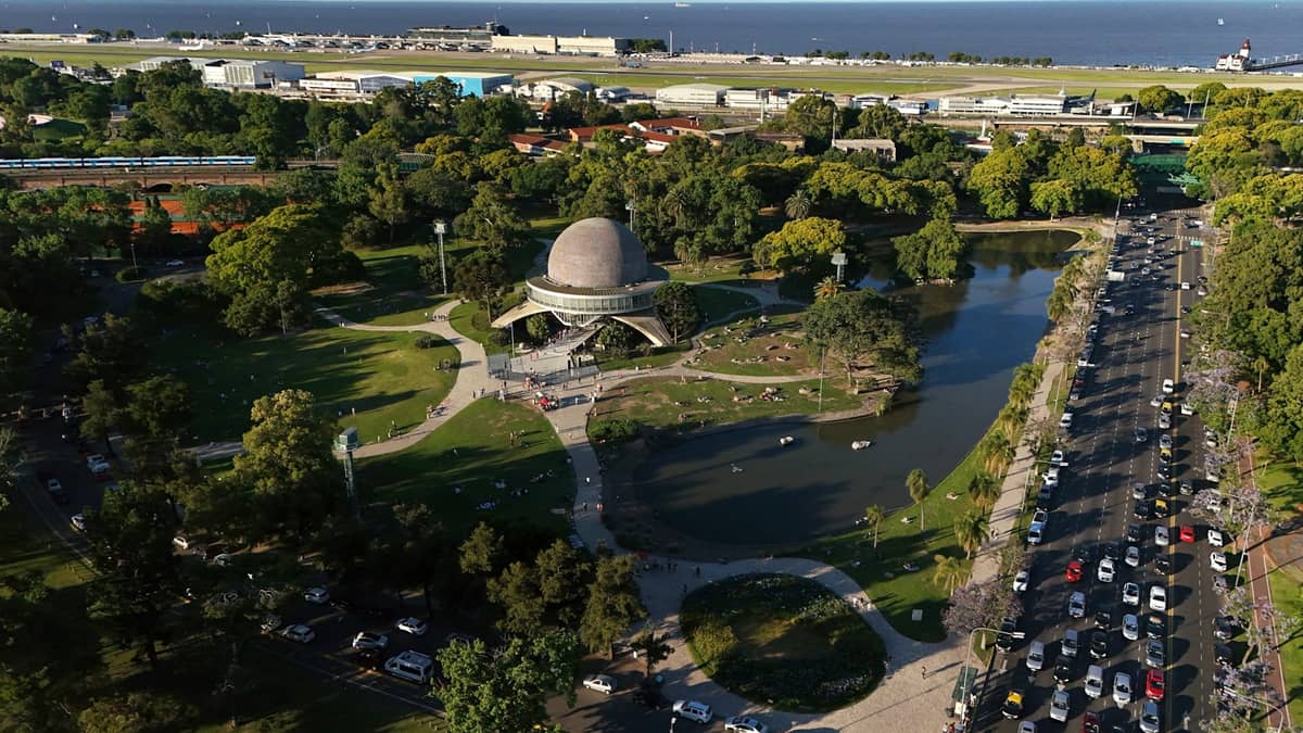 ภาพมุมสูงของ Planetario Galileo Galilei รายล้อมด้วยสวนและต้นไม้ สระน้ำ และถนนรถยนต์ในปาแลร์โม บัวโนสไอเรส