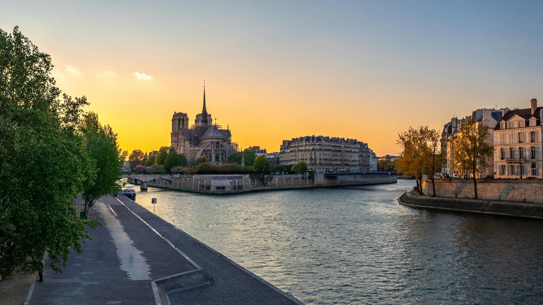 Sonnenuntergang über der Kathedrale Notre-Dame auf der Île de la Cité mit der Seine und der Promenade am Rive Gauche in Paris.