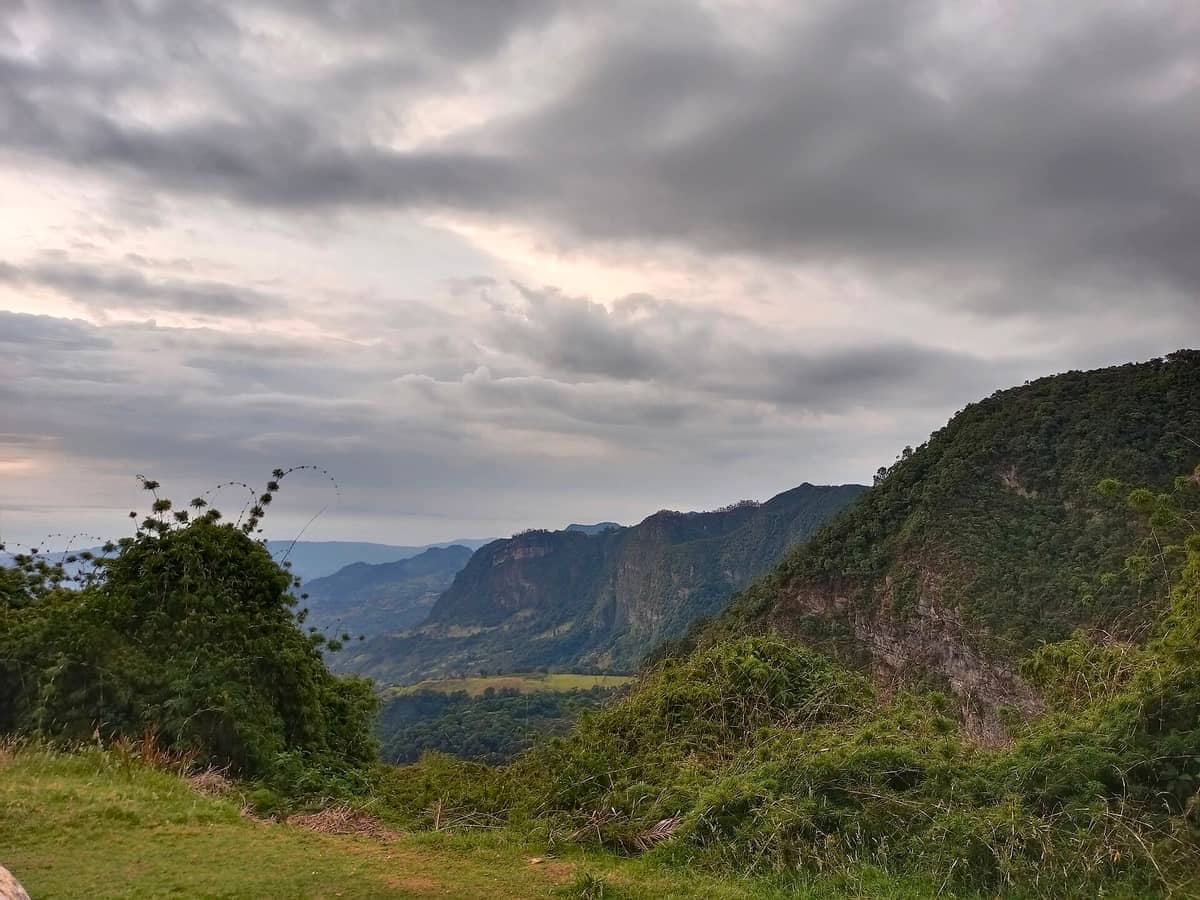 Lush green hills and dramatic cliffs of Parque Natural Chicaque under a cloudy sky in the Andean highlands near Bogotá.