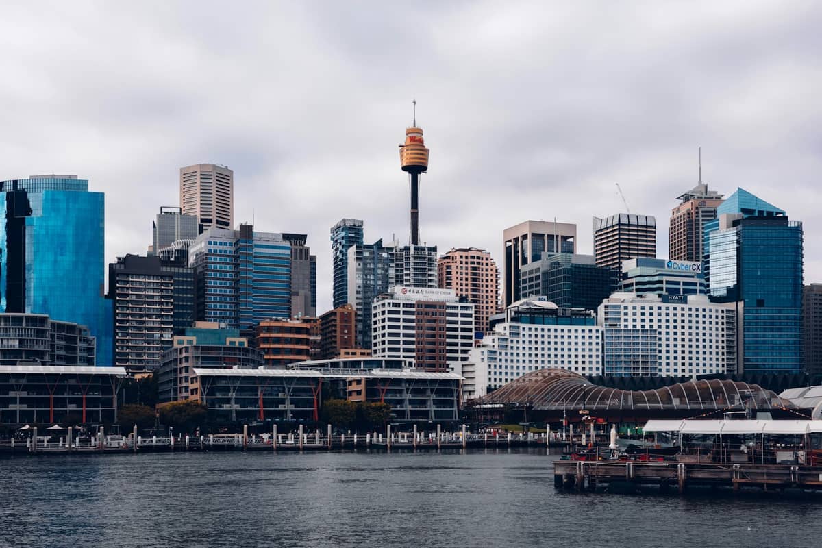 อาคารสูงสมัยใหม่และ Sydney Tower Eye อันเป็นสัญลักษณ์ริมน้ำภายใต้ท้องฟ้าครึ้ม วิวทิวทัศน์เมืองจาก Darling Harbour