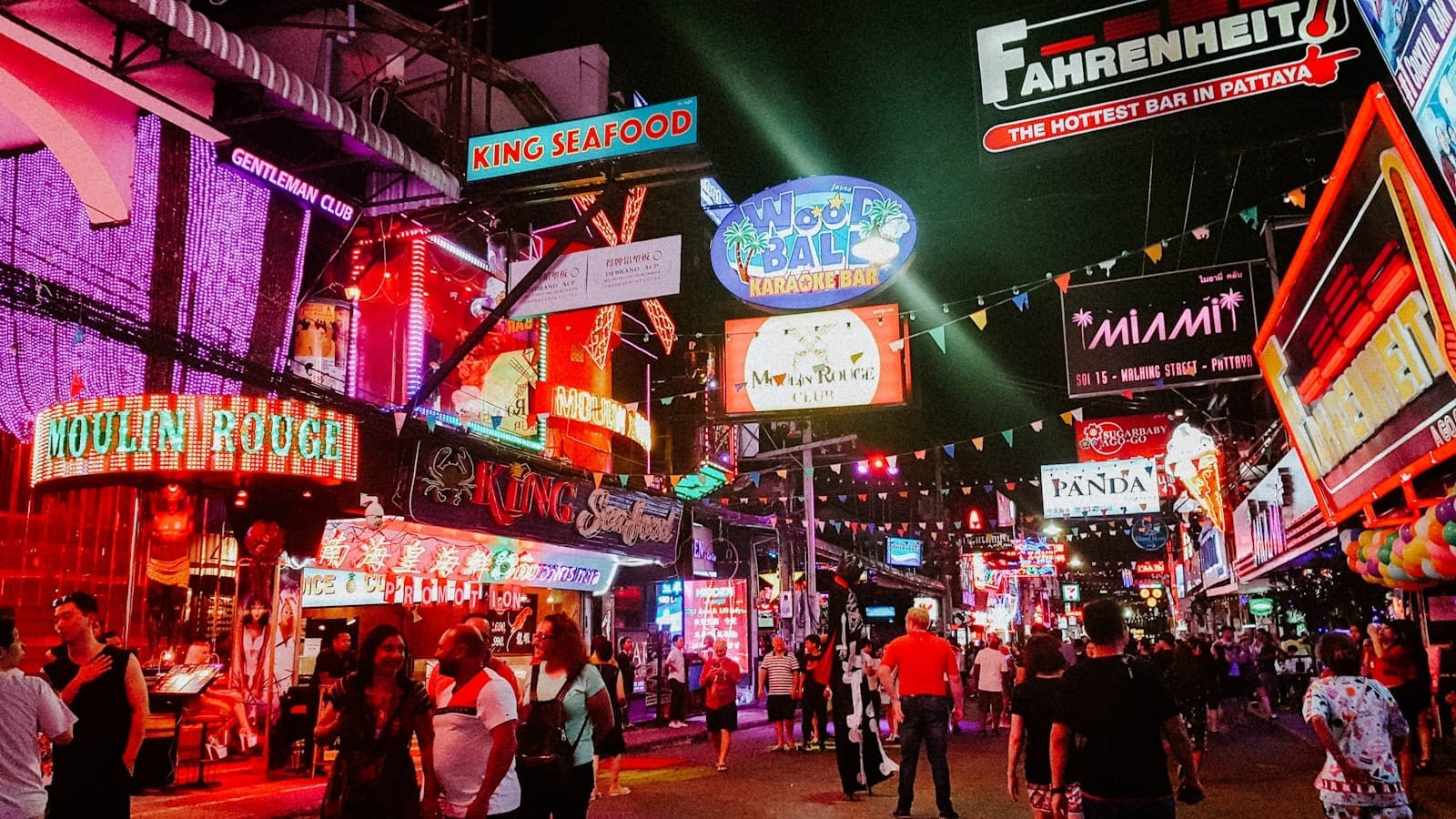 Le folle camminano sotto insegne al neon colorate e luci vivaci di bar, club e ristoranti sulla Pattaya Walking Street di notte.