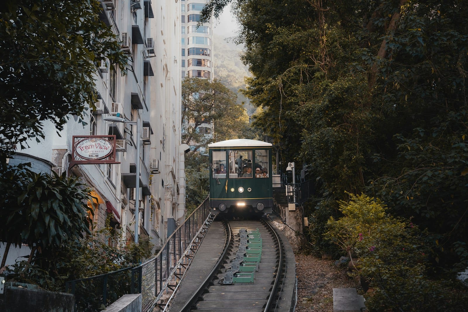 L'iconica Peak Tram che sale lungo binari ripidi attraverso il verde lussureggiante verso Victoria Peak.