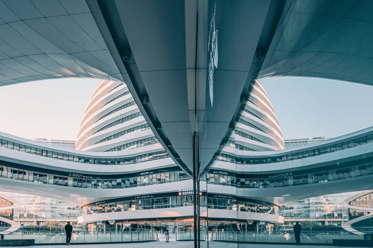 Modern architectural courtyard in Beijing's Galaxy SOHO complex, with sleek curved buildings and shops visible under daylight.