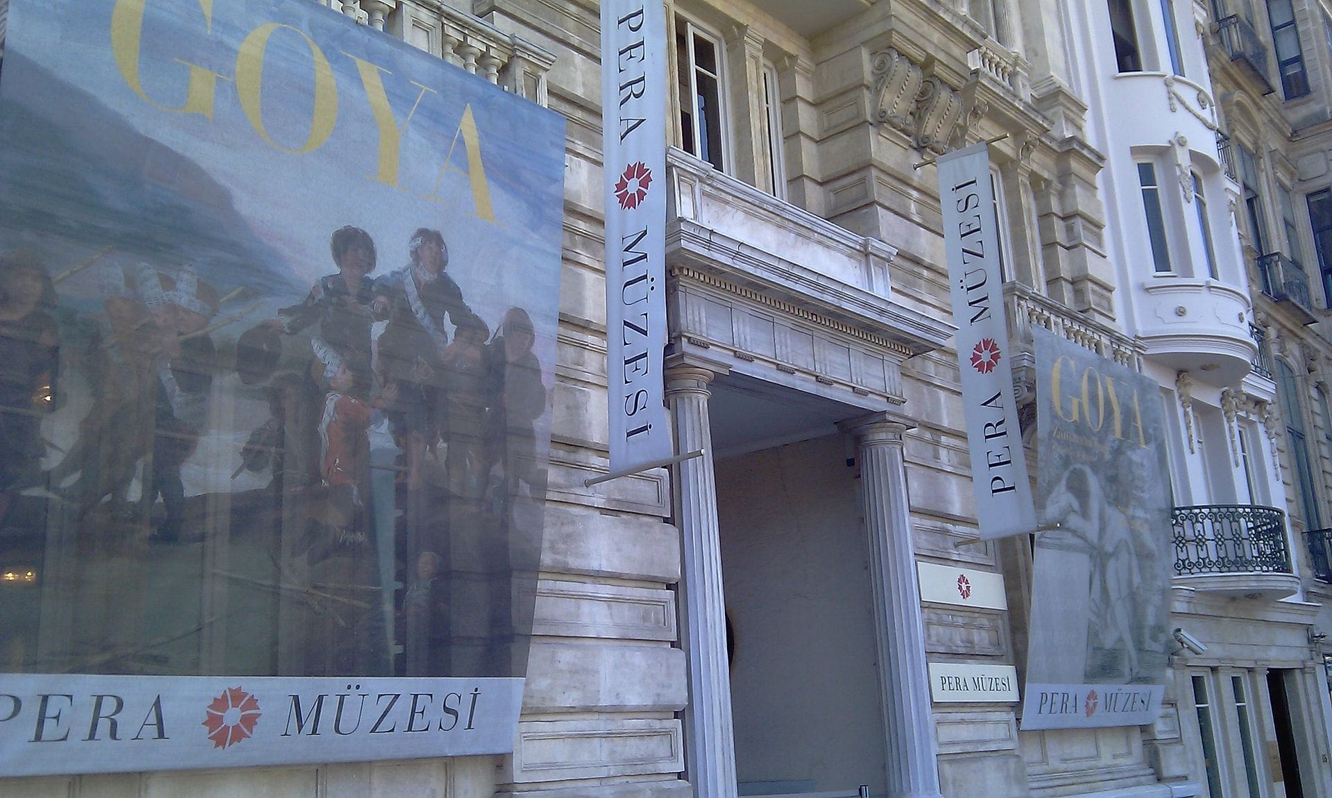 Facciata del Pera Museum a Istanbul con architettura classica, grandi striscioni per una mostra di Goya e insegne con la scritta 'Pera Müzesi' in turco.