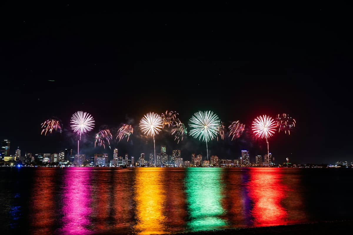 Kolorowe fajerwerki rozświetlają nocne niebo nad panoramą Perth, odbijając się żywymi barwami w wodach rzeki Swan podczas wielkiego festiwalu.