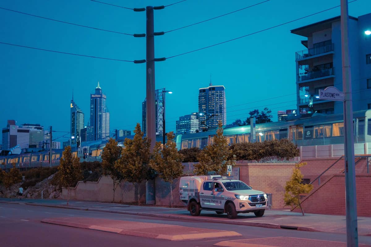 Abendliche Stadtansicht des Zentrums von Perth mit Skyline, einem Zug und modernen Gebäuden unter tiefblauem Himmel