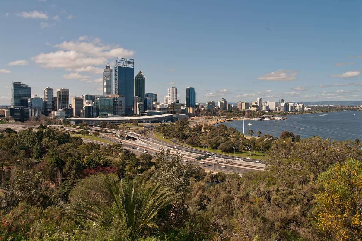 Panoramablick auf die Skyline von Perth vom Kings Park aus mit dem Swan River im Vordergrund und den Wolkenkratzern der Innenstadt unter einem klaren Himmel.