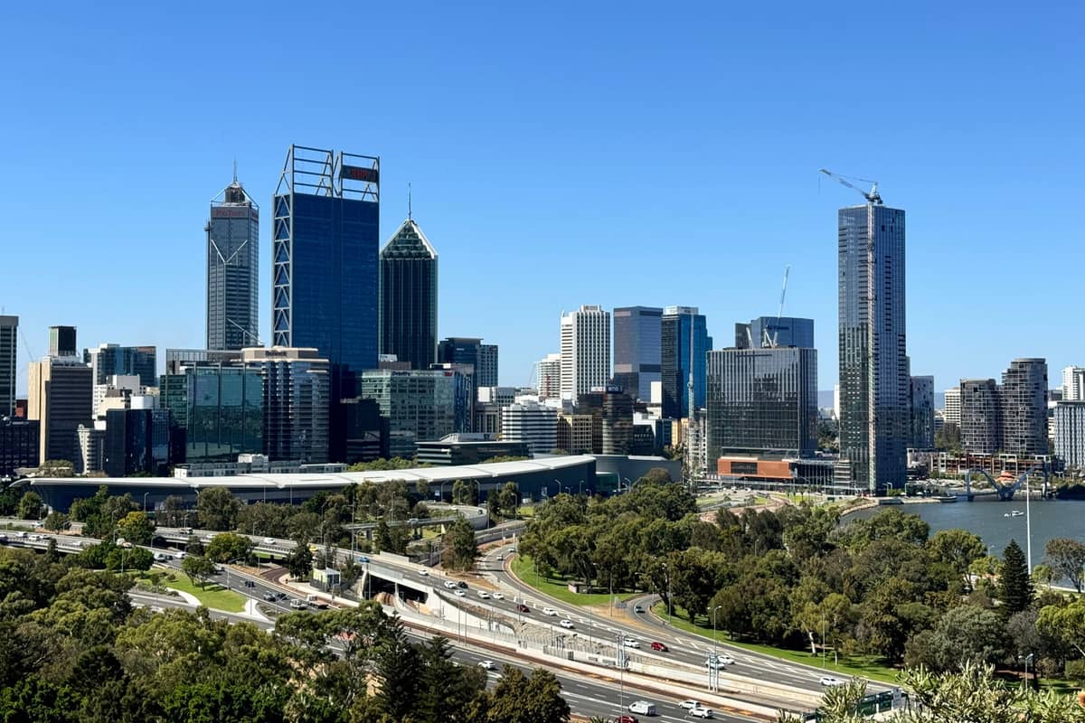 Skyline von Perth mit markanten Wolkenkratzern, Schnellstraße und dem Swan River an einem klaren, sonnigen Tag, von einem erhöhten Aussichtspunkt aus gesehen.