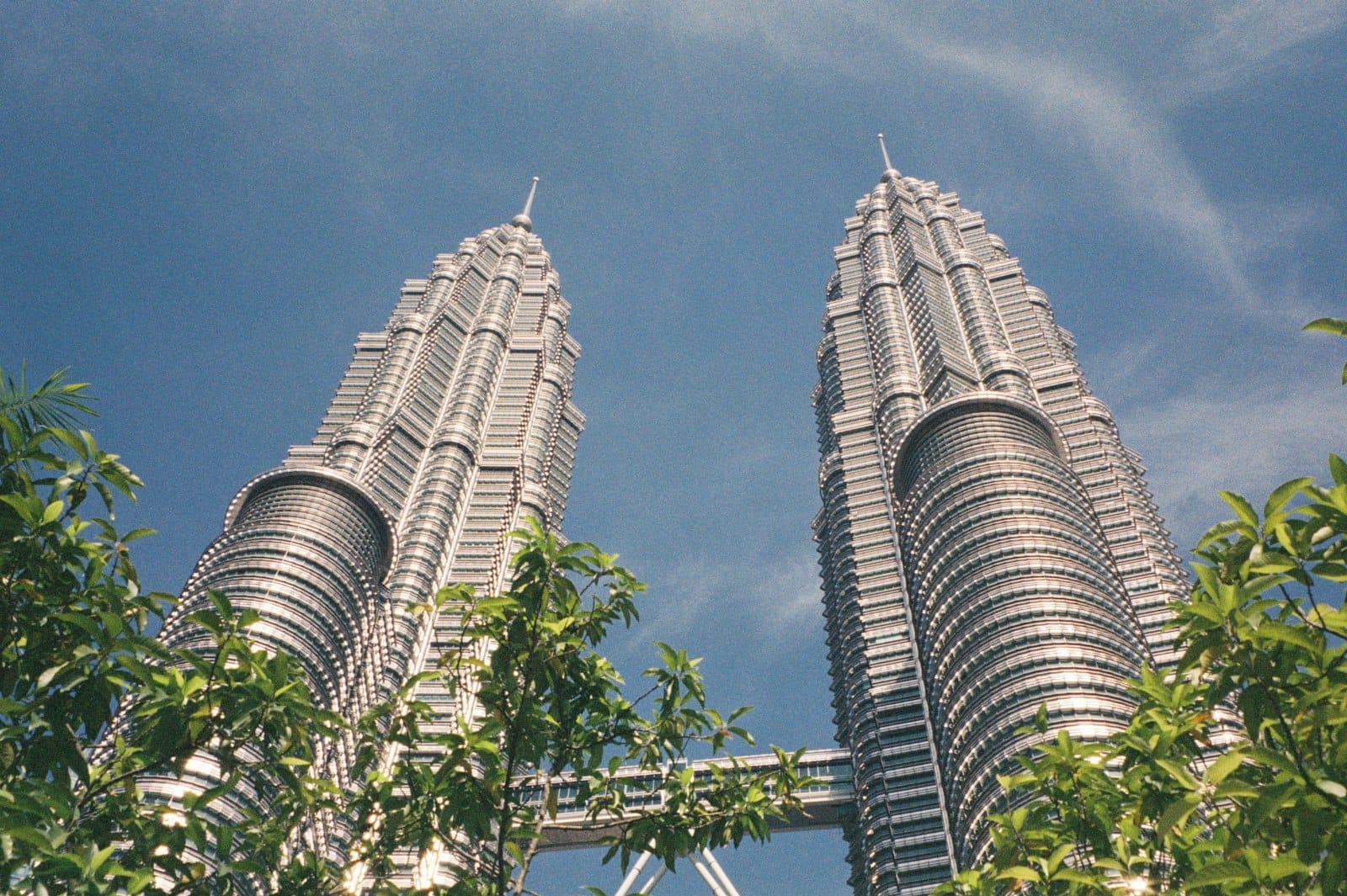 Iconic **Petronas Twin Towers** soaring above Kuala Lumpur skyline at dusk, stainless steel facades gleaming.