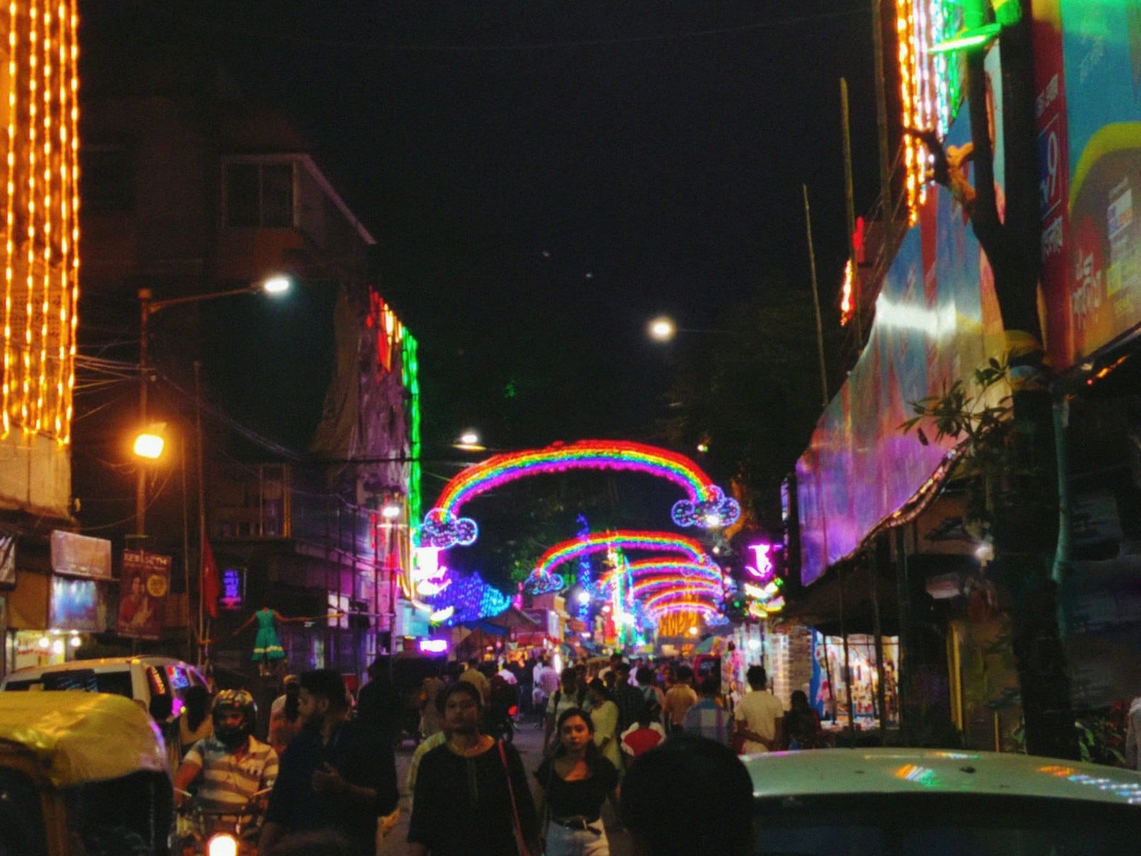 Crowded Bangla Road in Patong at night, with neon lights, busy street scene, and people walking under colorful archways.