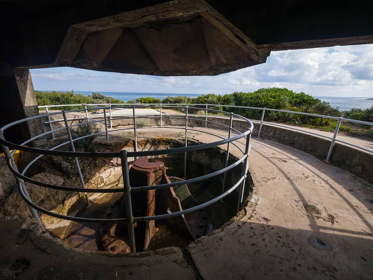Blick aus einer historischen Küstengeschützstellung im Point Nepean National Park, mit dem Meer und der Küstenbuschlandschaft im Hintergrund.