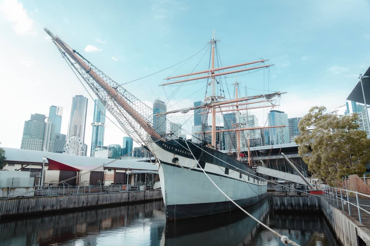 Die Polly Woodside, eine restaurierte eiserne Bark aus dem 19. Jahrhundert, liegt im South Wharf von Melbourne vor Anker, im Hintergrund die Wolkenkratzer der Stadt.