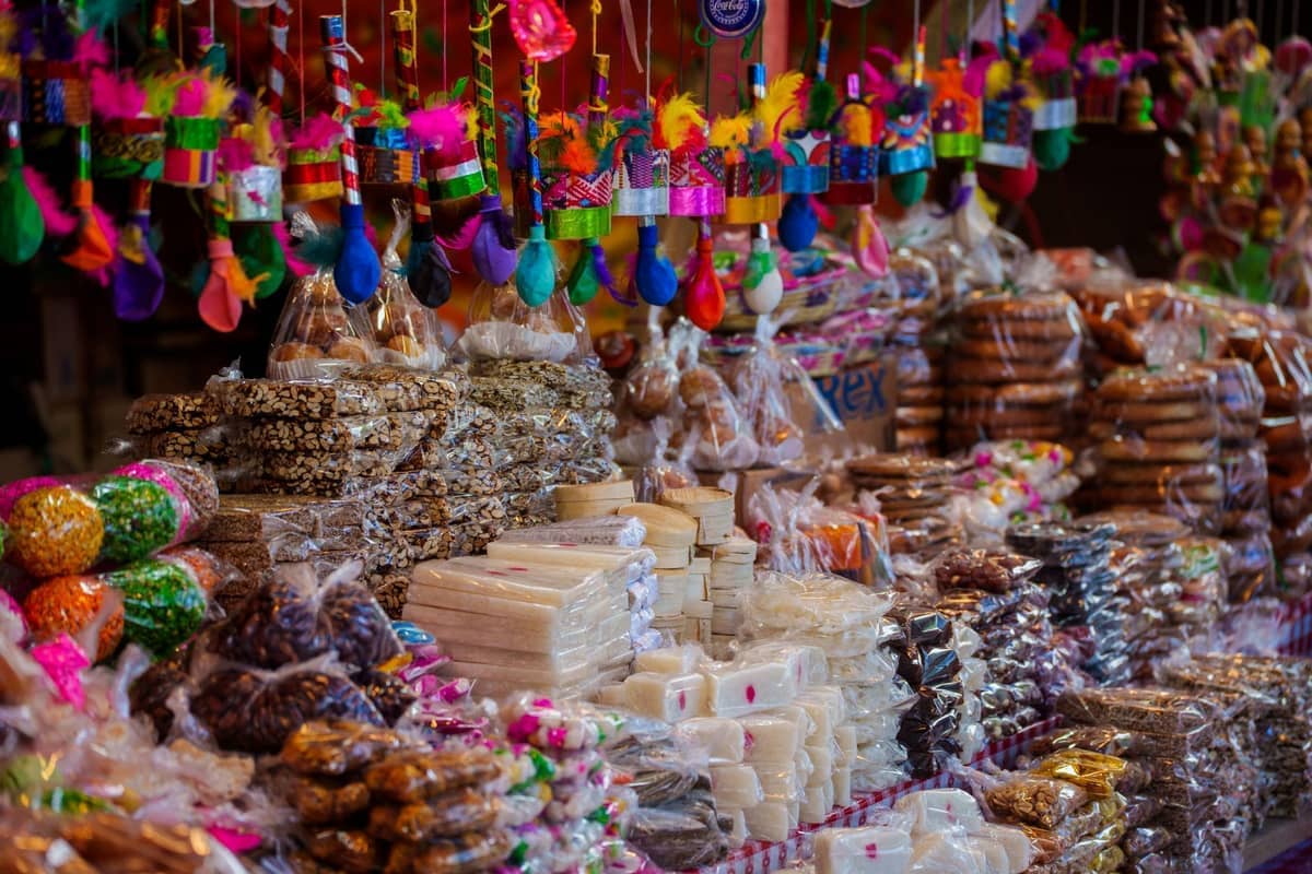 Stacks of colorful, handmade Caribbean sweets packaged in clear bags at Portal de los Dulces market stall in Cartagena’s historic center.