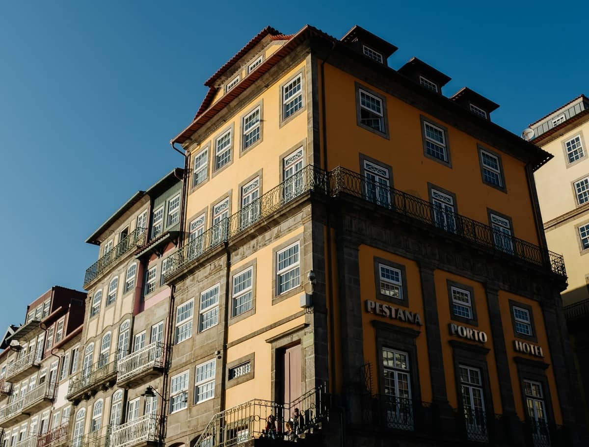 Elegante edificio storico a Porto con facciata gialla del Pestana Porto Hotel sotto un cielo azzurro limpido