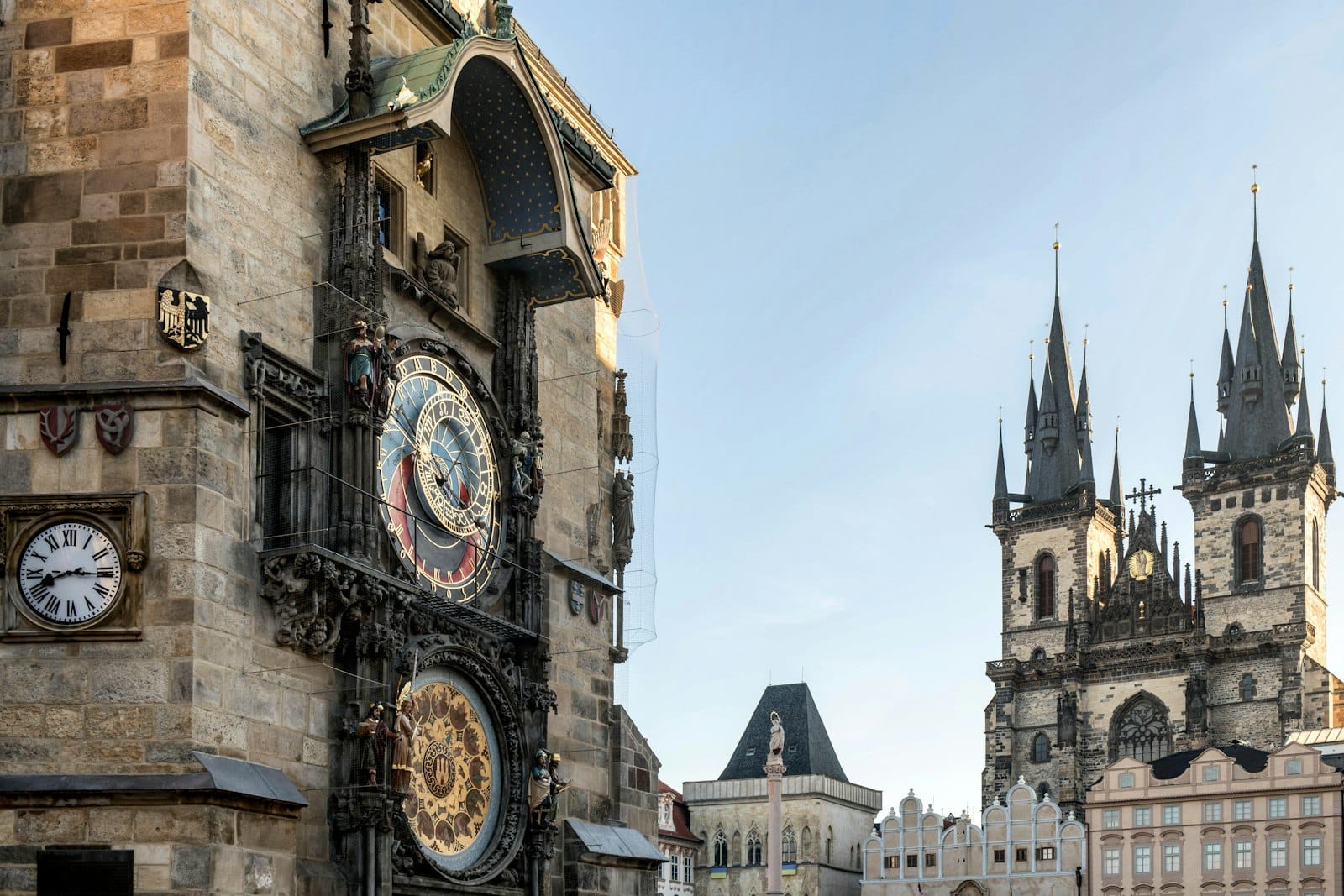Die Astronomische Uhr von Prag und die gotischen Türme der Týnkirche auf dem Altstädter Ring unter einem klaren Himmel.