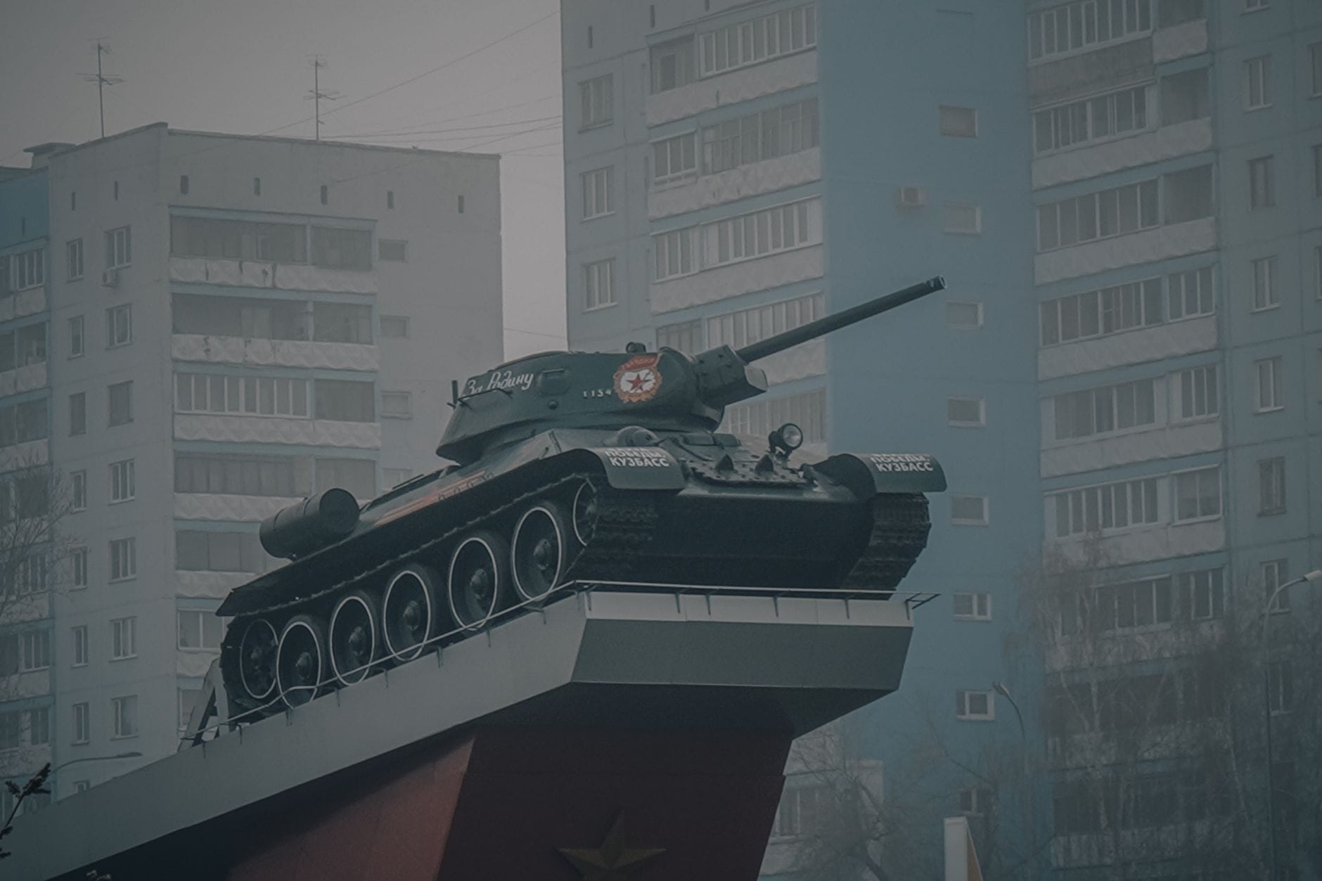 Ein sowjetisches Panzer-Denkmal auf einem Sockel mit Wohngebäuden im Hintergrund, das an David Černýs berühmten rosa Panzer-Protest in Prag erinnert.