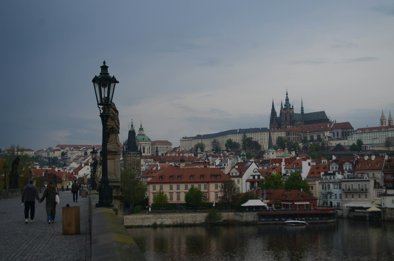 Blick von der Karlsbrücke über die Vltava mit der Prager Burg und Malá Strana im Hintergrund, mit historischer Architektur und romantischer Atmosphäre.