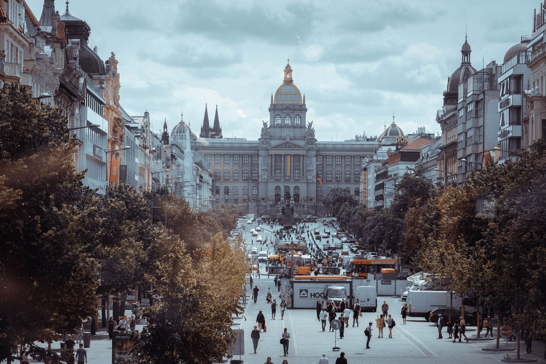Vista di Piazza Venceslao a Praga con il Museo Nazionale sullo sfondo e persone che camminano per la strada.