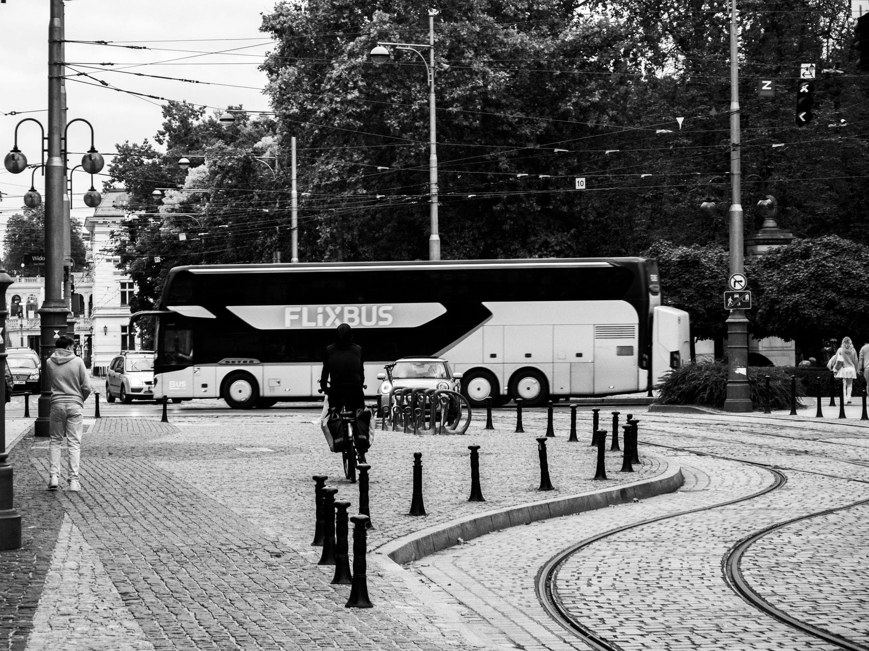 Autobus FlixBus che percorre strade acciottolate con binari e i dintorni della città di Praga in vista.