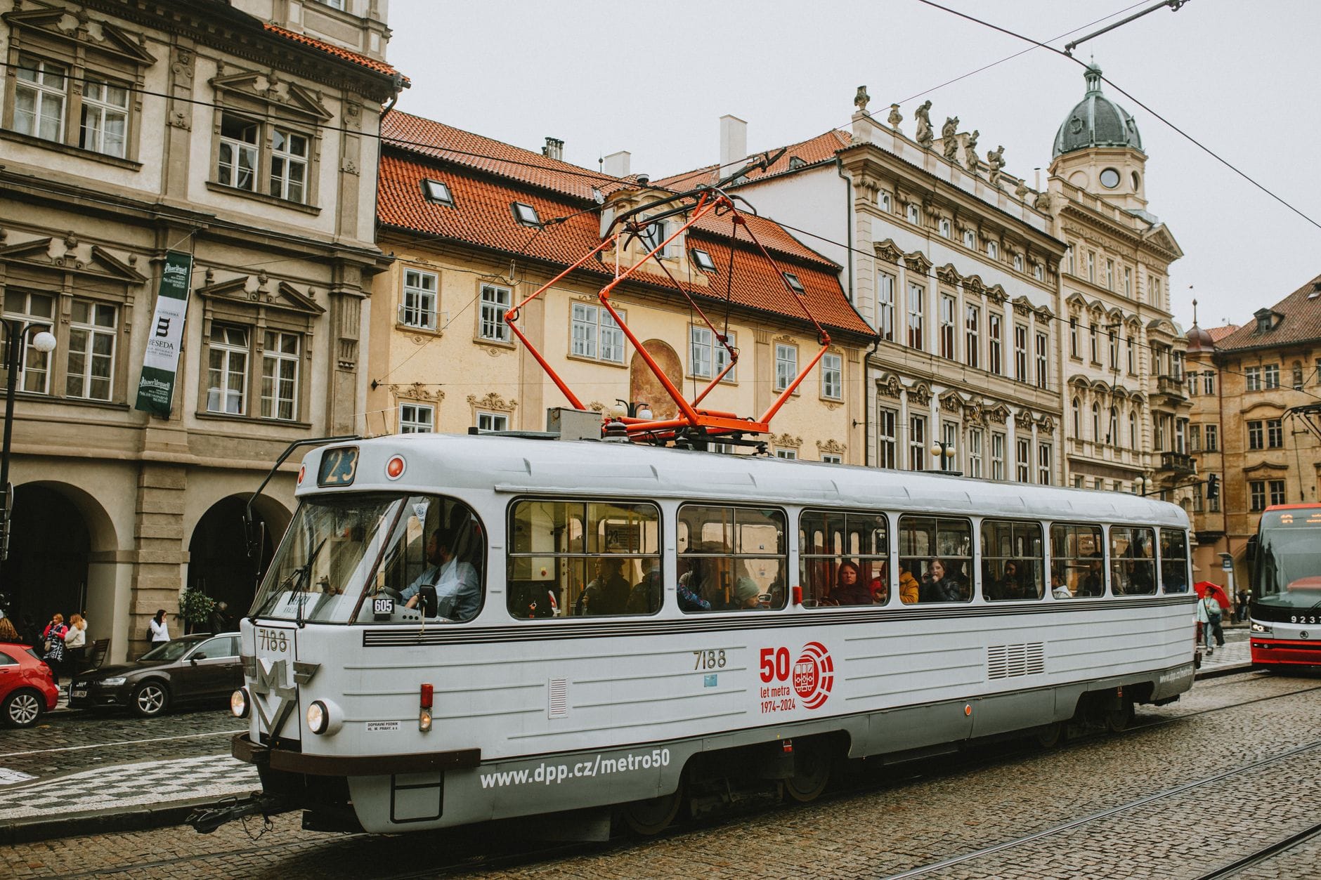 Classic Prague tram traveling through historic city center with cobblestone streets and ornate buildings in the background