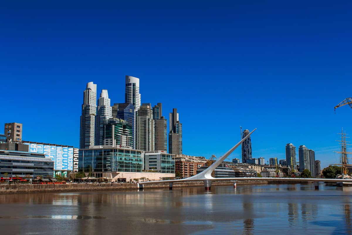 สะพานคนเดิน Puente de la Mujer พาดข้ามริมน้ำที่ Puerto Madero, บัวโนสไอเรส รายล้อมด้วยตึกสูงทันสมัย ใต้ท้องฟ้าสีฟ้าสดใส