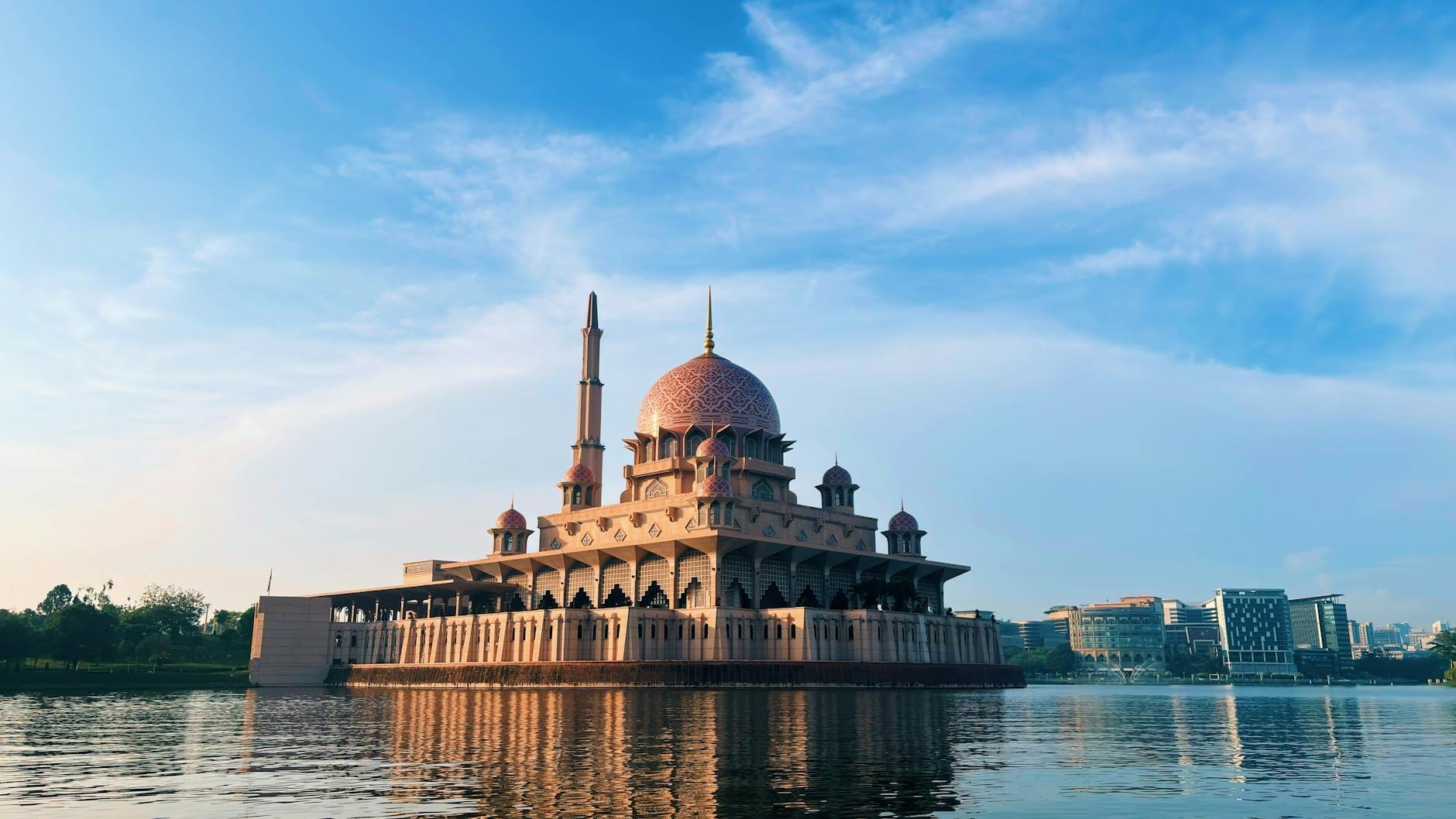Serene Putrajaya Lake reflecting grand government buildings, mosques, and ornate bridges in Malaysia's planned capital.