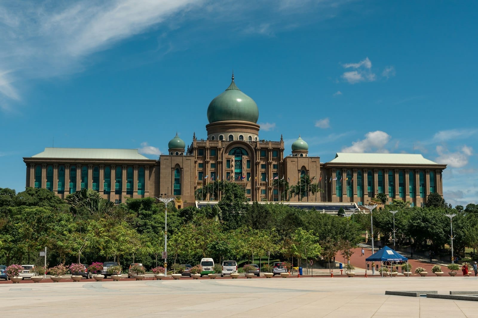 Majestic domes of Perdana Putra rise above manicured greenery in Putrajaya, radiating calm under a bright, cloud-dotted sky.