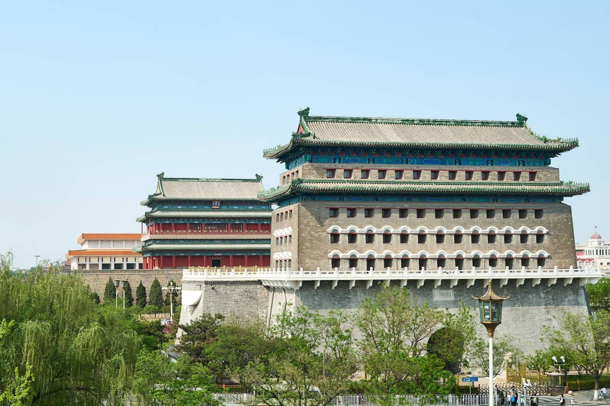 Klare Tagesansicht des Qianmen-Torturms und des ebenso historischen Zhengyangmen-Pfeilturms, umgeben von Grünflächen am südlichen Ende von Pekings Zentralachse.