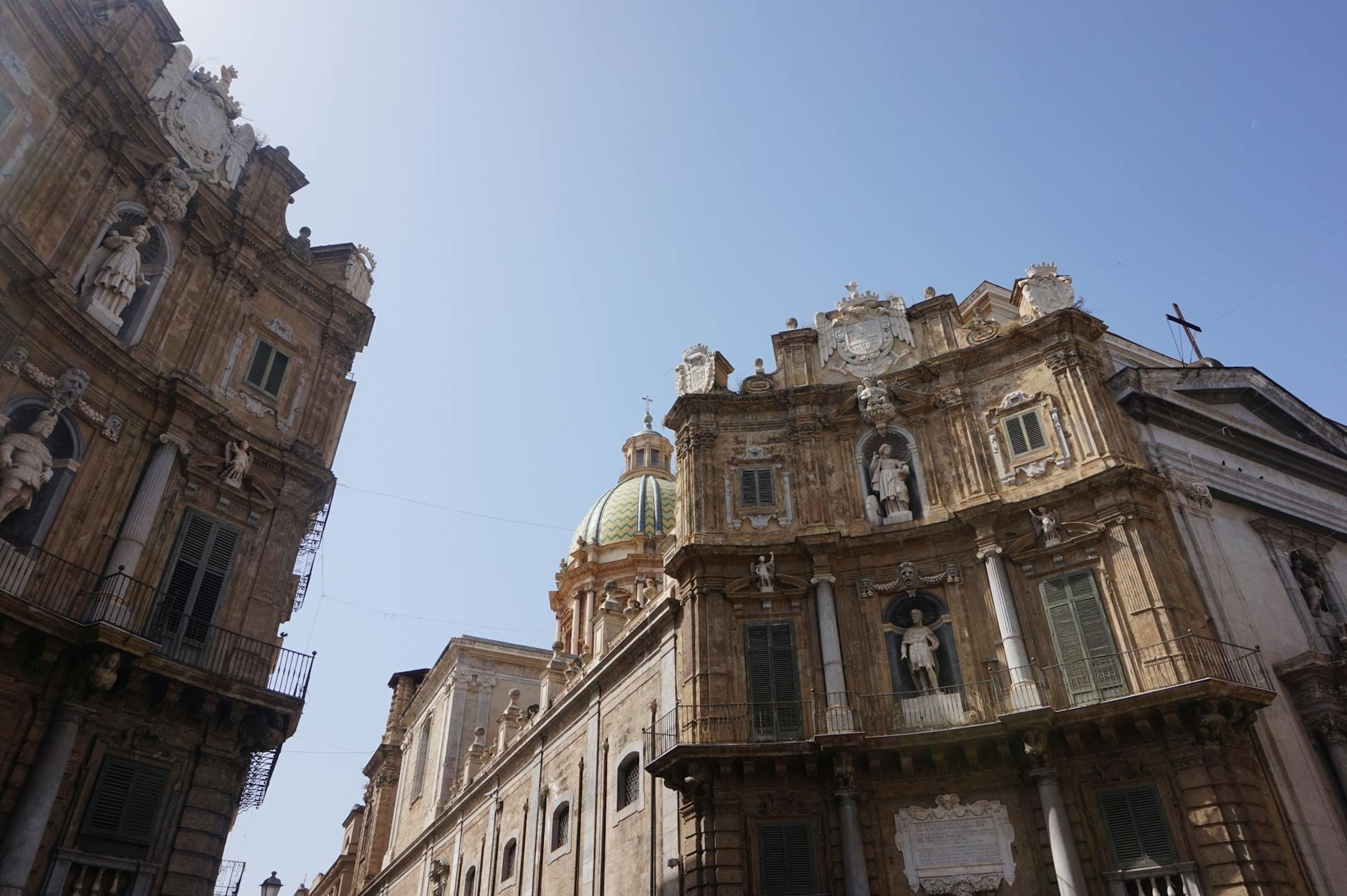 Zwei der prunkvollen Barockfassaden der Quattro Canti wölben sich unter strahlend blauem Himmel einander entgegen – im Herzen Palermos.