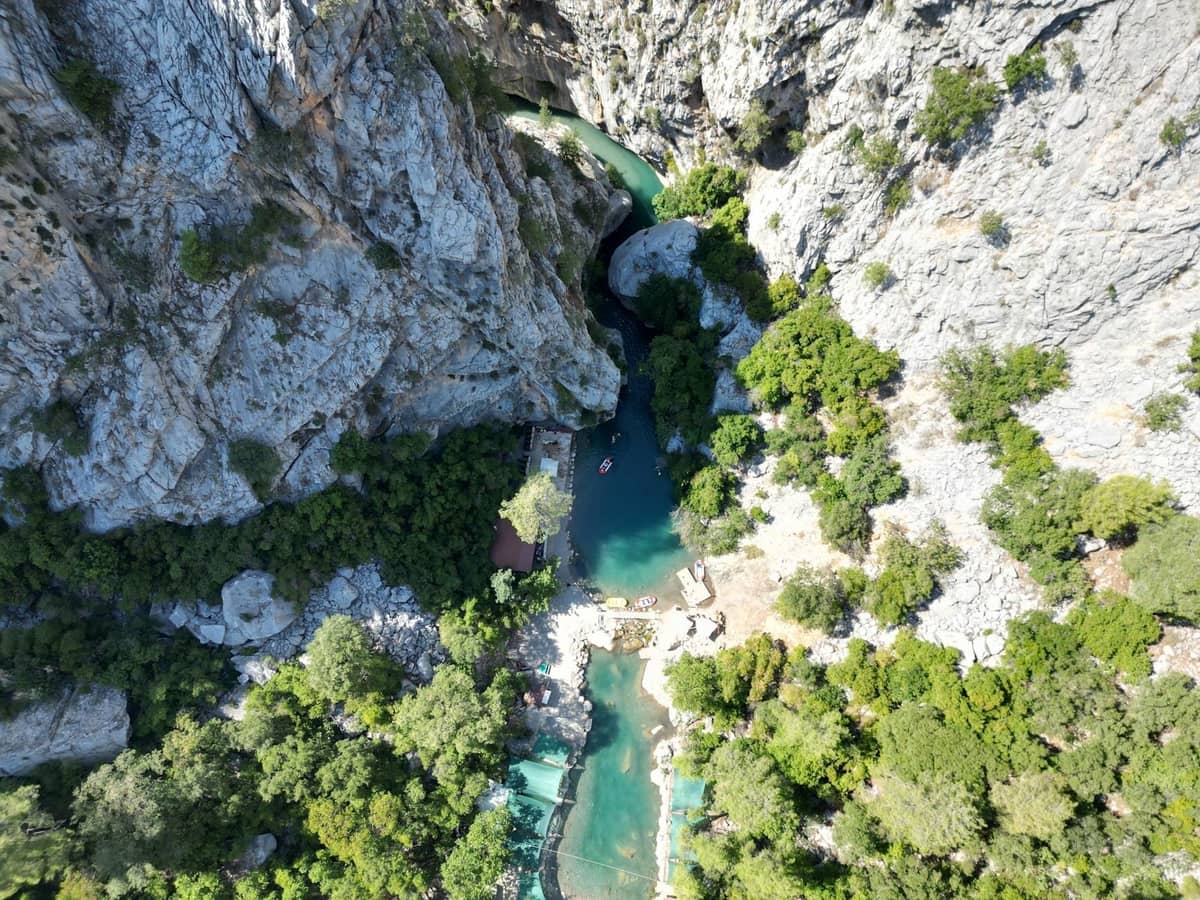 Aerial view of the turquoise river winding through dramatic limestone cliffs and lush greenery in Köprülü Canyon National Park, Antalya.