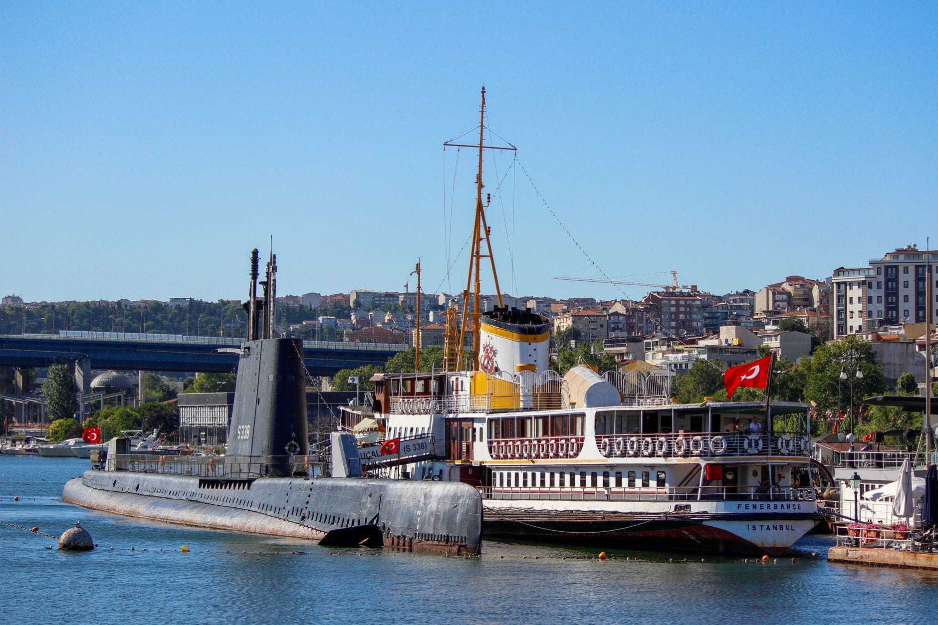 Un sottomarino storico e un piroscafo d'epoca ormeggiati fianco a fianco al Museo Rahmi M. Koç sul Corno d'Oro a Istanbul in una giornata di sole.