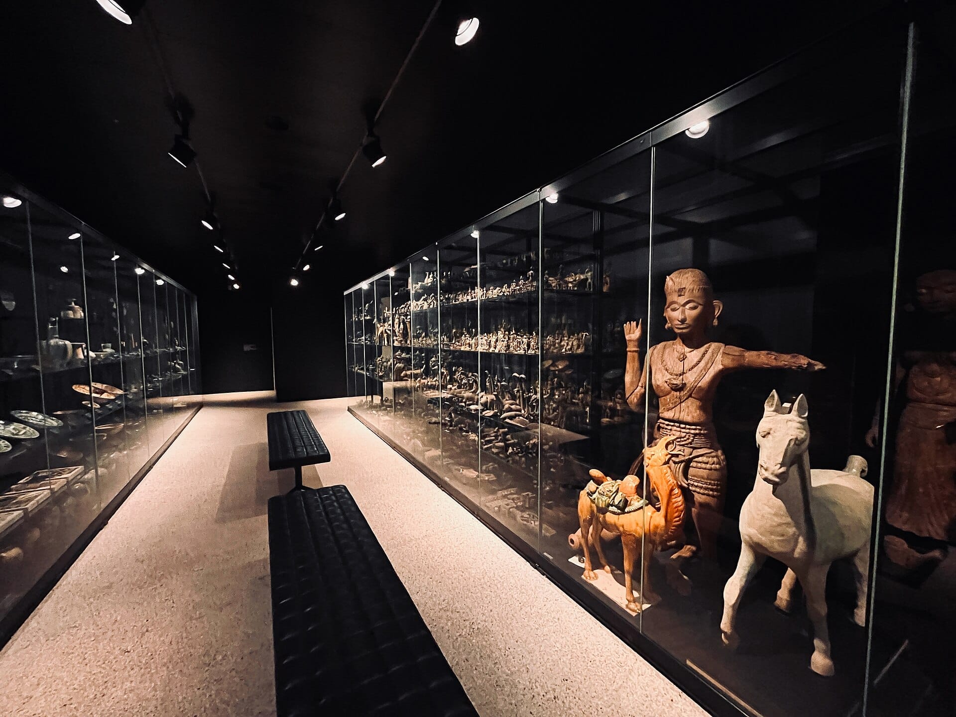ตู้กระจกแสดงผลงานที่ Museum Rietberg จัดแสดงประติมากรรมนอกยุโรปที่ประณีต รวมถึงรูปปั้นขนาดใหญ่ของคน ม้า และอูฐภายใต้แสงพิพิธภัณฑ์