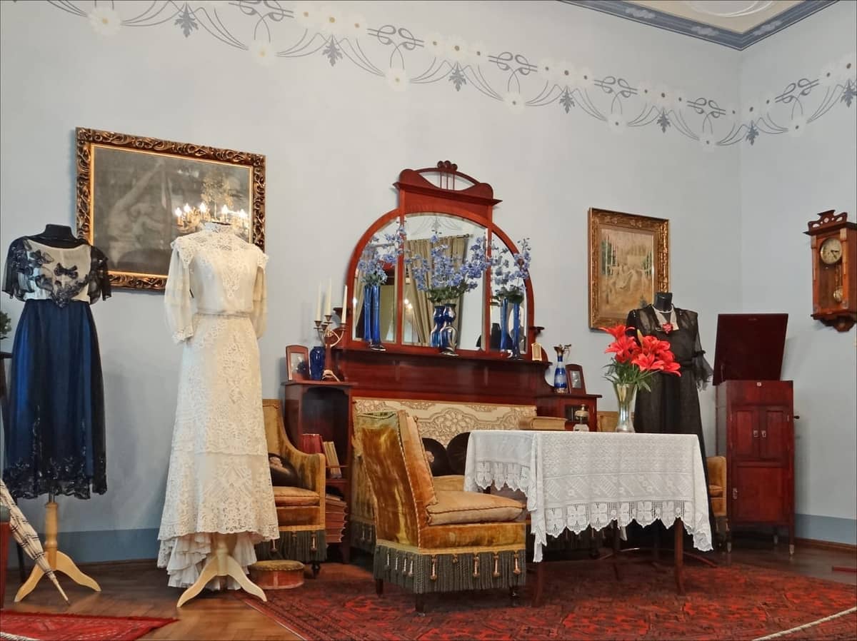Jugendstil-Interieur im Rigaer Jugendstilmuseum mit Vintage-Möbeln, dekorativem Spiegel, antiken Kleidern und detaillierten Wandschablonen in der Alberta iela.