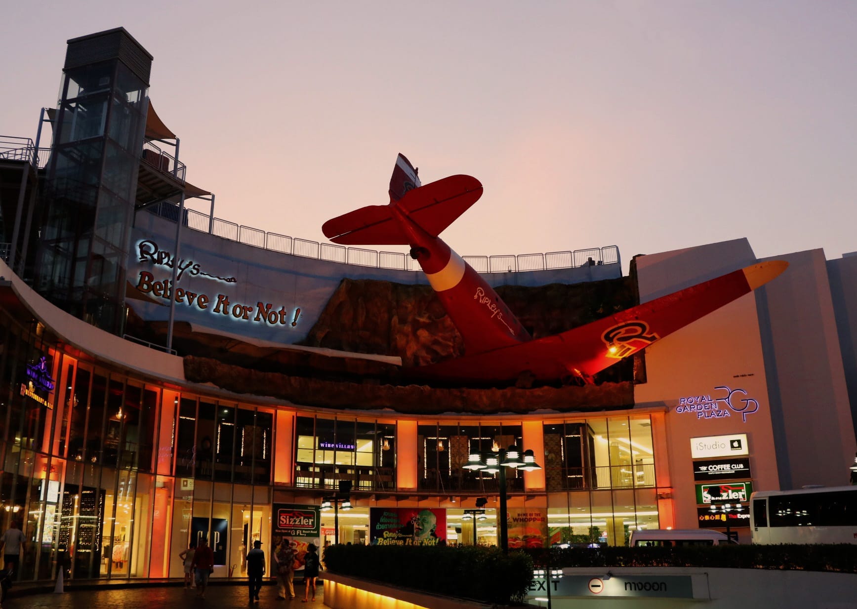 Esterno del Ripley's Believe It or Not! Pattaya al tramonto, con una spettacolare installazione di un aereo rosso sopra l'ingresso del Royal Garden Plaza.