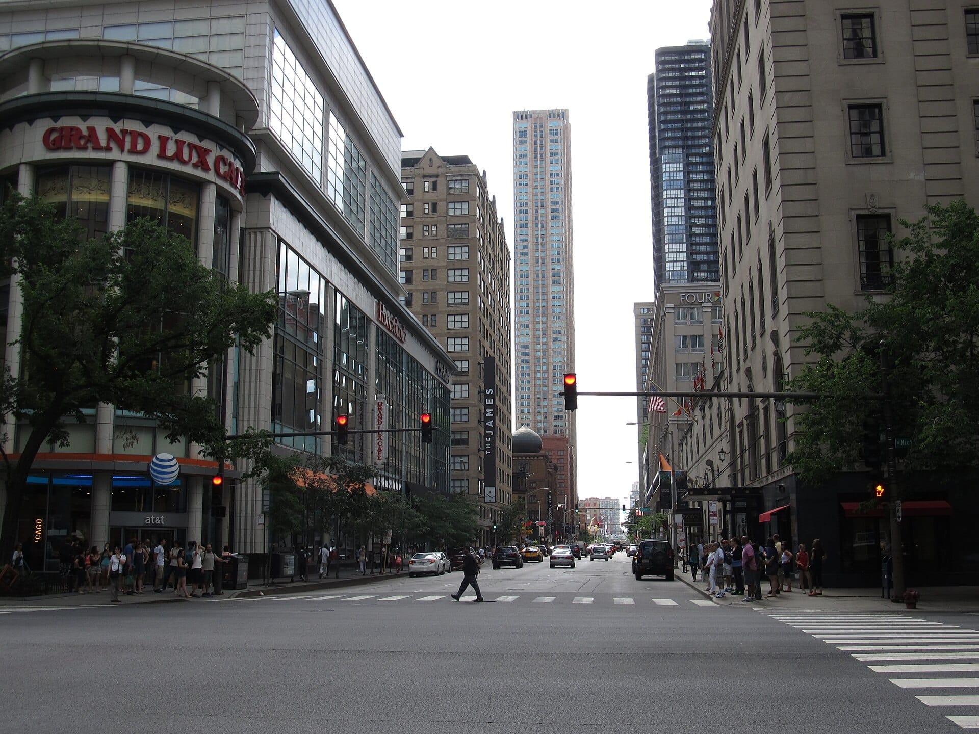 Incrocio nel River North Gallery District di Chicago con edifici alti, negozi come il Grand Lux Cafe, lampioni e persone in attesa di attraversare.