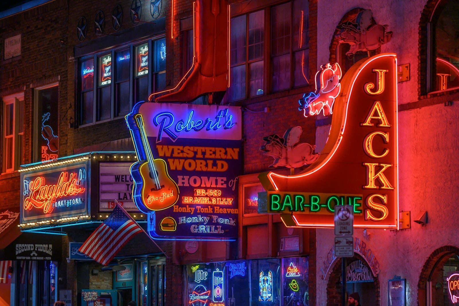 Los letreros de neón de Robert's Western World y los honky-tonks vecinos iluminan Broadway en Nashville de noche, capturando la vida nocturna auténtica y la vibrante escena musical.