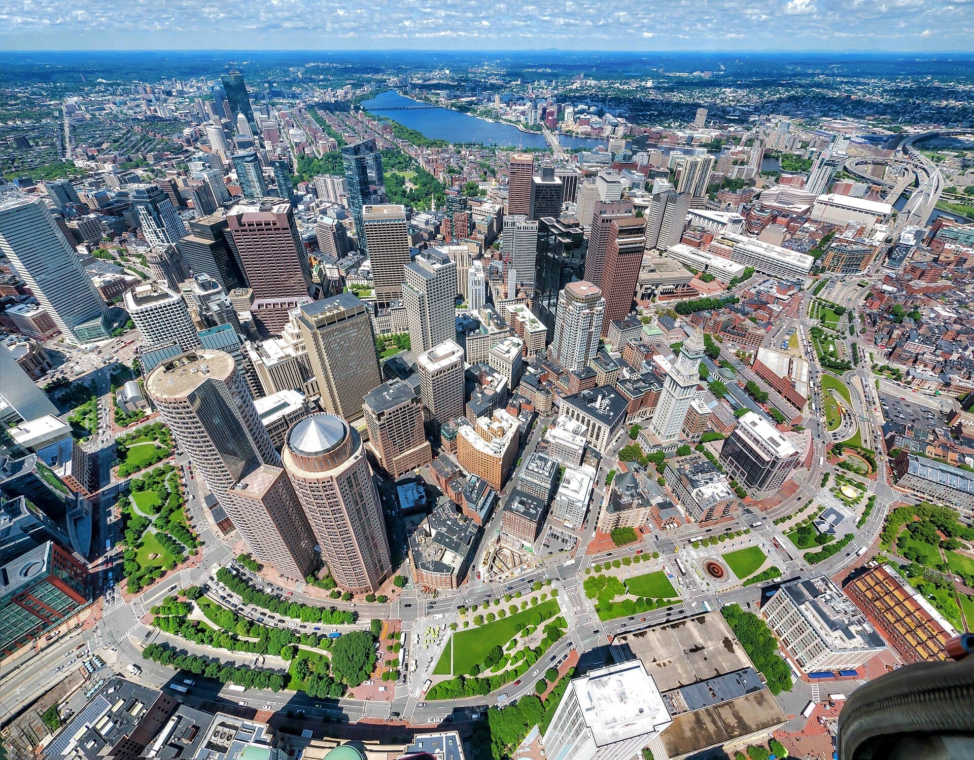 Vista aerea del centro di Boston con il Rose Kennedy Greenway che si snoda tra grattacieli, parchi verdi e strade cittadine in una giornata di sole.