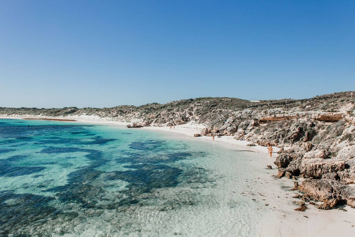น้ำทะเลใสกับชายหาดขาวบน Rottnest Island ท่ามกลางโขดหินและท้องฟ้าสีฟ้าสด เป็นภาพไฮไลต์ของชายฝั่งชื่อดังบนเกาะ