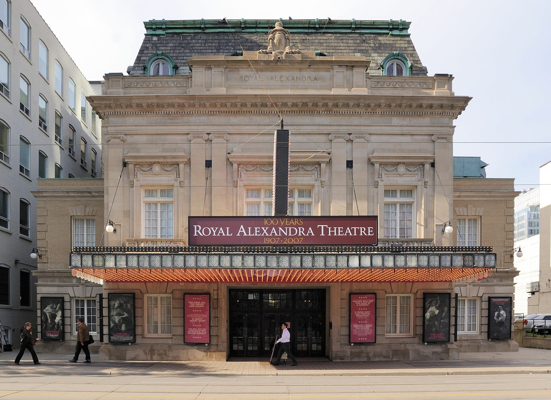 มุมมองด้านหน้าของ Royal Alexandra Theatre อันเก่าแก่ในโตรอนโต แสดงให้เห็นส่วนหน้าอาคารสไตล์ Beaux-Arts ที่ประดับประดาอย่างงดงามและไฟป้ายมาร์คีขนาดใหญ่ในเวลากลางวัน