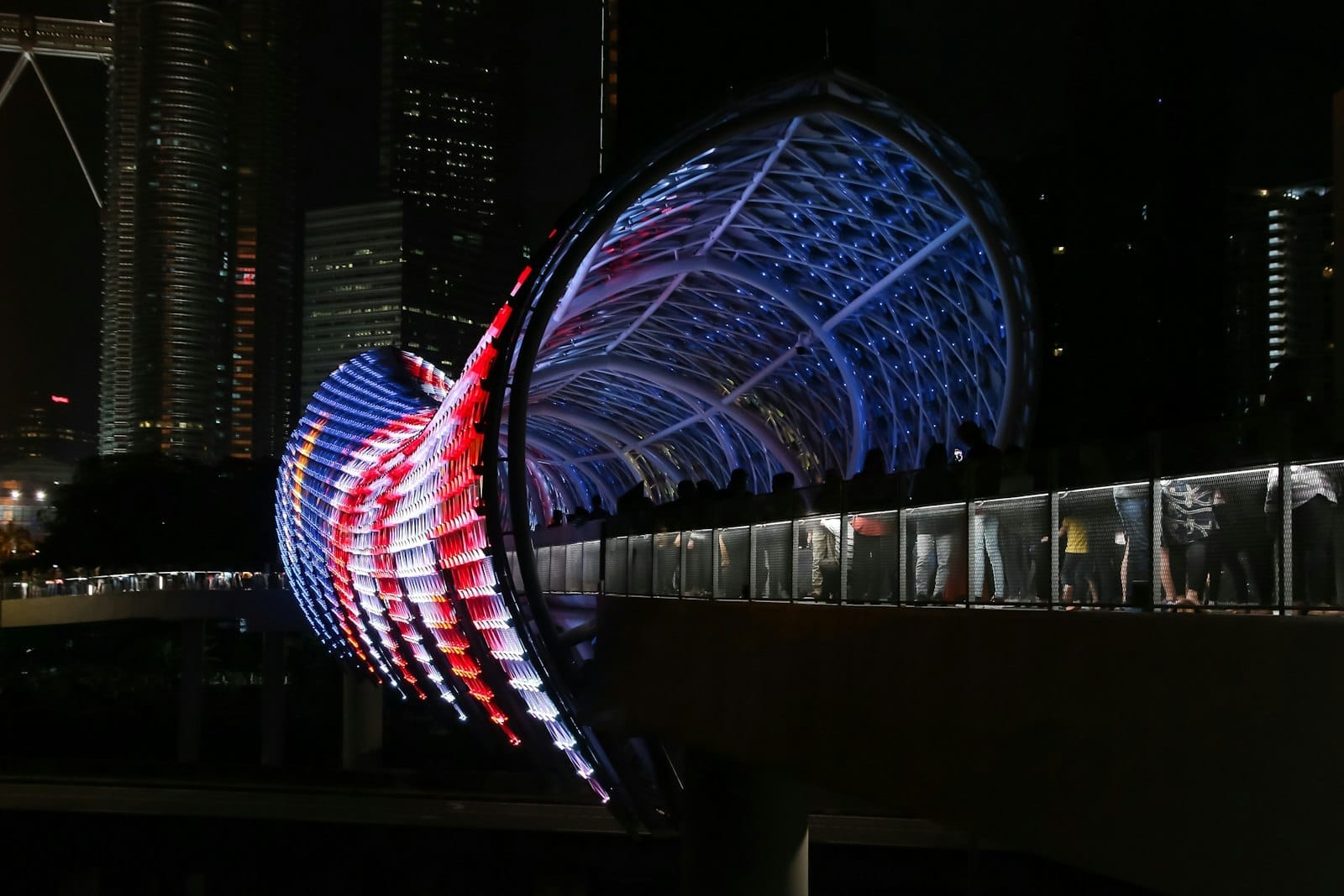 Sweeping curves of the illuminated Saloma Link bridge spanning Kuala Lumpur's Klang River at night.