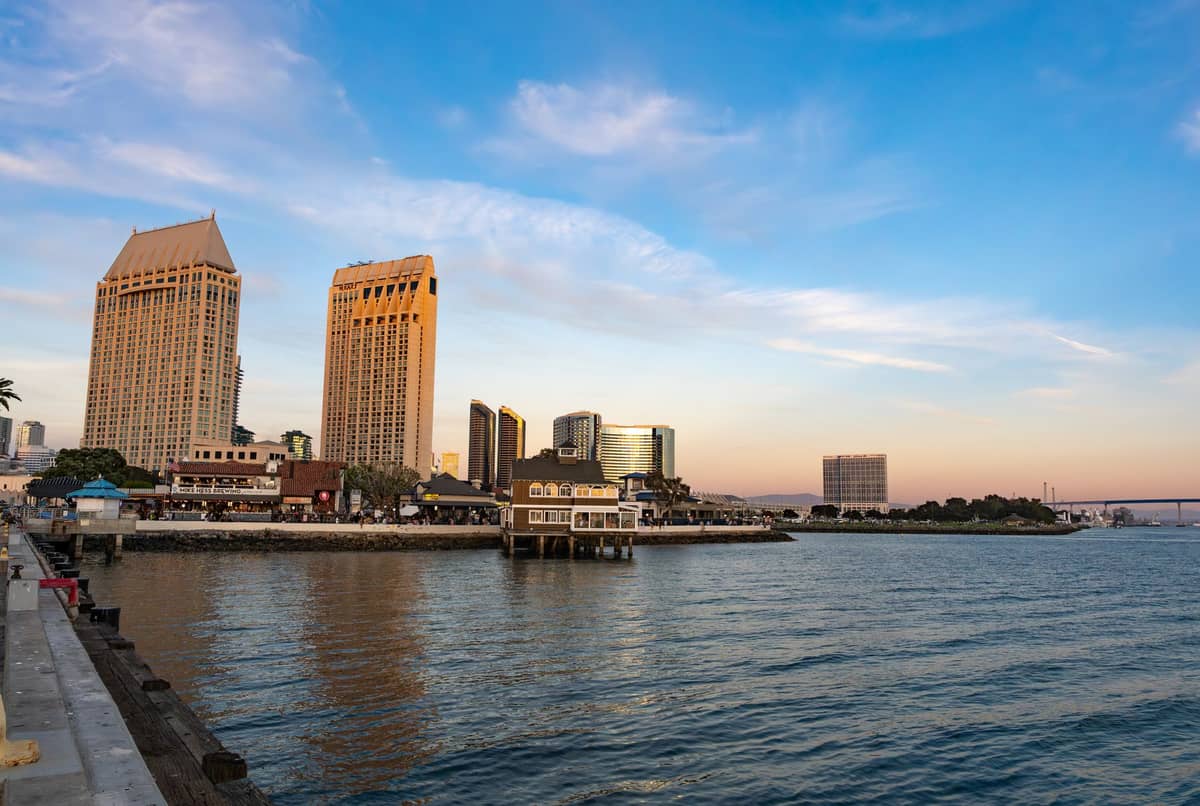 Blick auf die Uferpromenade von San Diego bei Sonnenuntergang mit markanter Skyline und klarem blauem Himmel