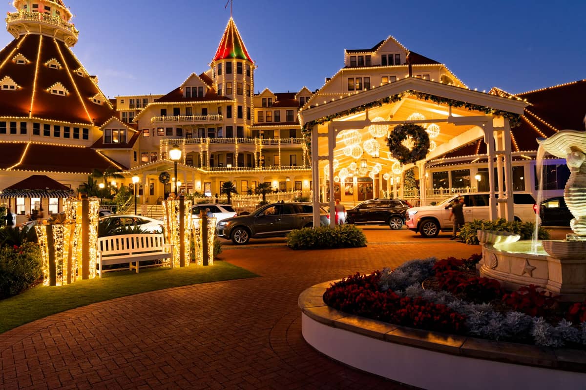 Hotel del Coronado in San Diego bei Nacht mit festlichen Feiertagslichtern und einem großen Kranz am Eingang geschmückt