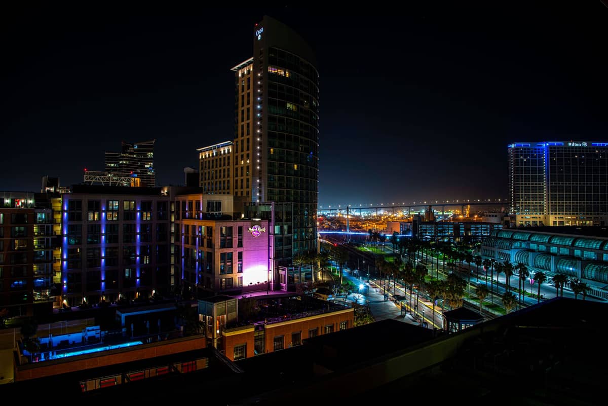 วิวยามค่ำคืนของอาคารสมัยใหม่และโรงแรมในใจกลางเมือง San Diego พร้อมแสงไฟสีสันสดใสและถนนในเมือง มองจากด้านบน
